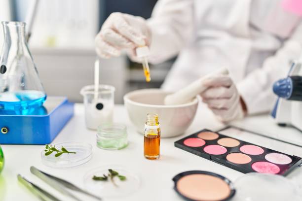 Young hispanic woman scientist making makeup working at laboratory